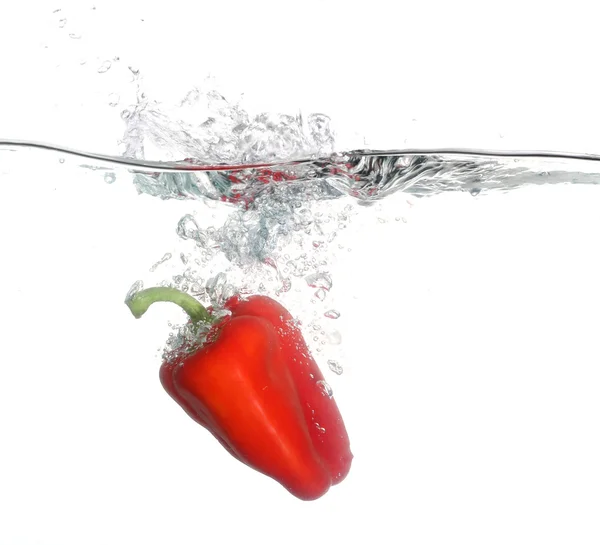 Rødt pepper som faller i vann over hvit bakgrunn – stockfoto