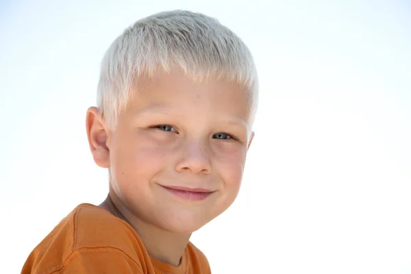 Young blonde kid smiles in orange shirt — Stock Photo, Image