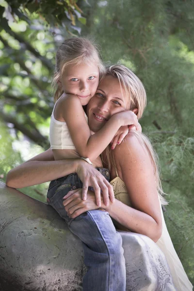 Lovely blonde young girl and mother hug outdoor — Stock Photo, Image