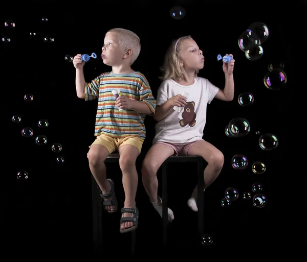 Menino e menina fluxo bolhas — Fotografia de Stock