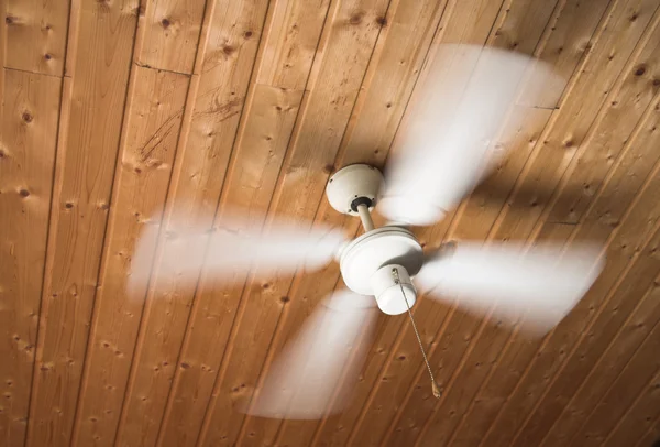 Деревянный потолок, белый вентилятор вращается быстро — стоковое фото