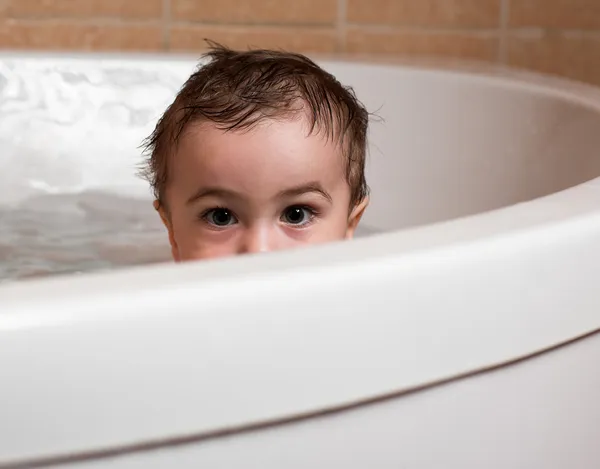 Menino pequeno senta-se na banheira, olhos — Fotografia de Stock