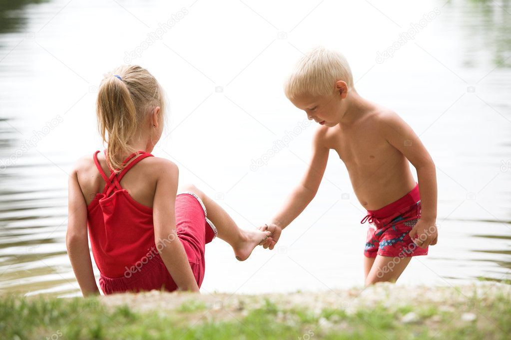 Little boy and girl on a river bank