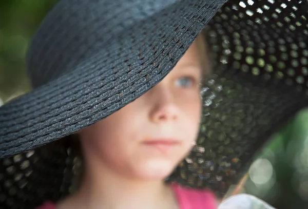 Liten flicka i en stor hatt — Stockfoto