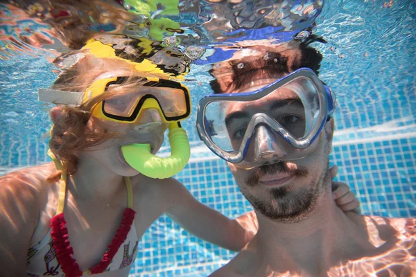 Батько і його дочка під водою в басейні — стокове фото