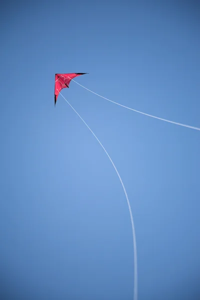 Red kite, blue sky, white strings — Stock Photo, Image