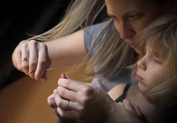 Mutter schneidet Nägel mit Schere — Stockfoto