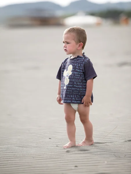 Küçük çocuk kumsalda yürür — Stok fotoğraf