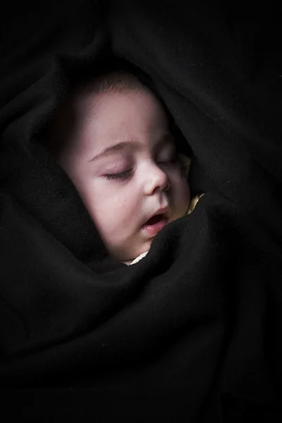 Little baby rolled up in a black blanket — Stock Photo, Image