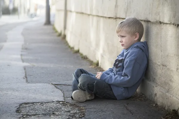 Magányos kisfiú ül út — Stock Fotó
