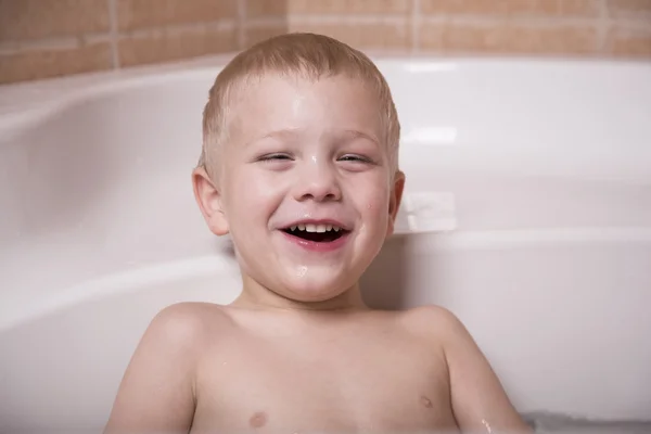Ung pojke skratt i badkar — Stockfoto