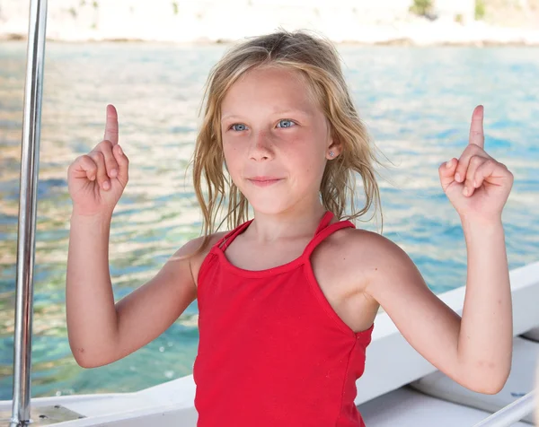 Giovane ragazza su una barca con due dita in su — Foto Stock