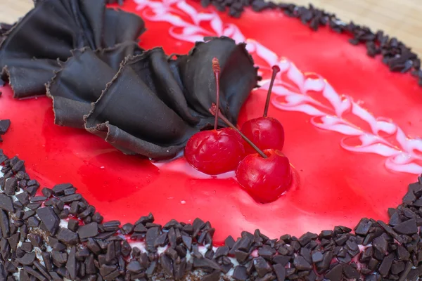 Schokoladenkuchen mit einer roten Kirsche — Stockfoto