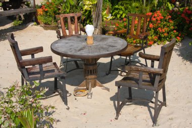 Table and chairs in a tropical garden clipart