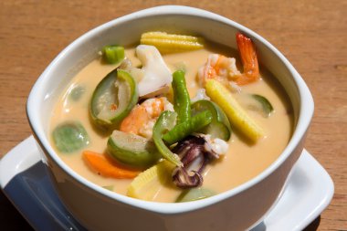 Thai soup made from coconut milk and seafood clipart