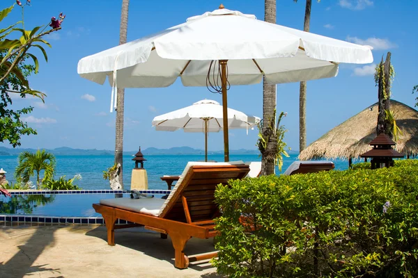 Deniz mavi Yüzme Havuzu su ve palmiye ağaçları oteller. — Stok fotoğraf