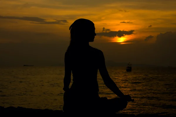 Dziewczyna medytuje w zachód słońca — Zdjęcie stockowe