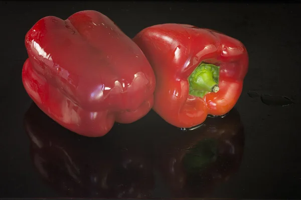 Δύο κόκκινες πιπεριές σε μαύρο φόντο — Φωτογραφία Αρχείου