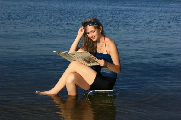 Girl with a book on the sea — Stock Photo, Image