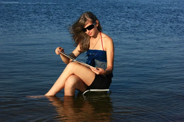 Chica con un libro sobre el mar —  Fotos de Stock