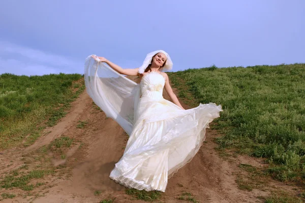 Bride dancing in a field — Stock Photo, Image