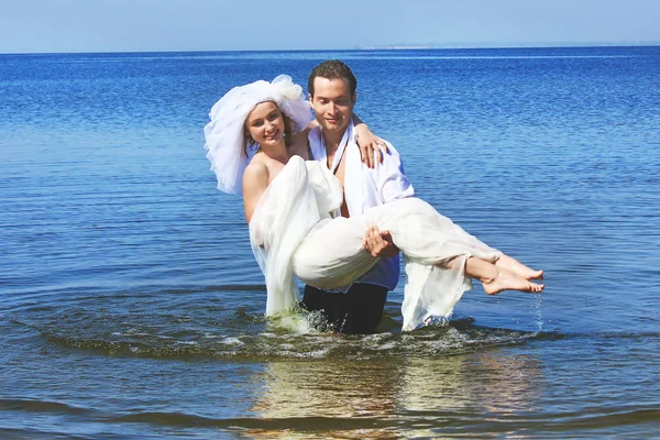 Bride and groom in the water — Stock Photo, Image