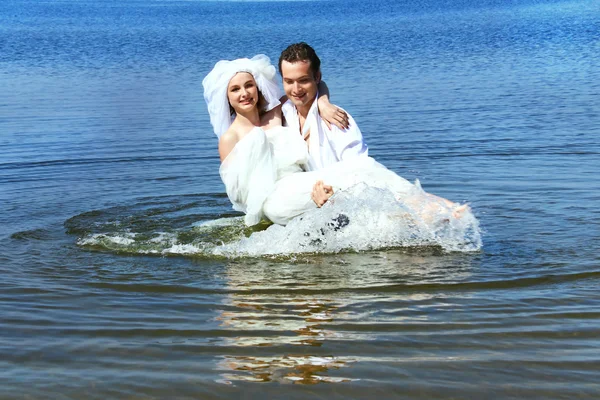 Bride and groom in the water — Stock Photo, Image
