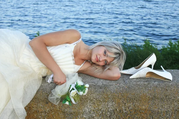 Nevěsta na pozadí moře s svatební kytice — Stock fotografie