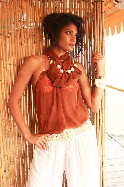 Flicka brunett i östra klänning på en bakgrund av bambu — Stockfoto