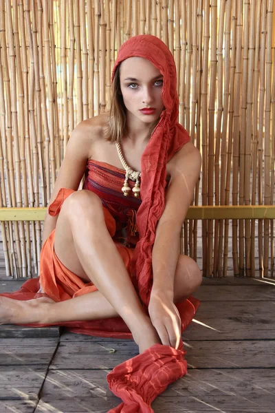 Chica en vestido oriental sobre un fondo de bambú — Foto de Stock