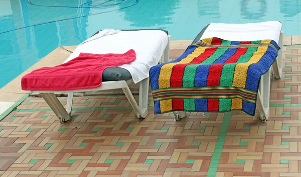 放松与毛巾在游泳池附近的椅子 — 图库照片