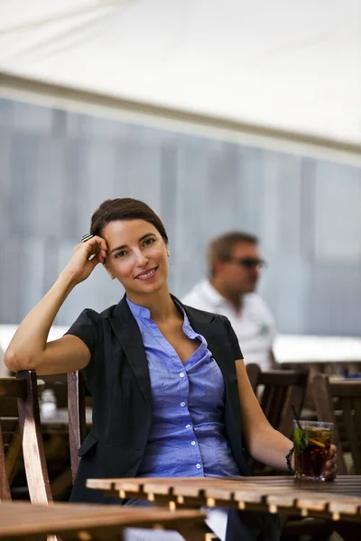 Mujer bonita y joven sentada al aire libre — Foto de Stock