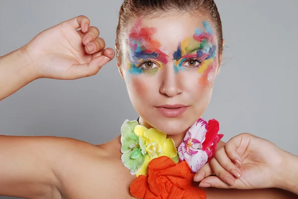 Mooie jonge vrouw met geschilderde make-up — Stockfoto