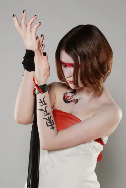 Mooi meisje in Japanse stijl met rode make-up en lichaam — Stockfoto