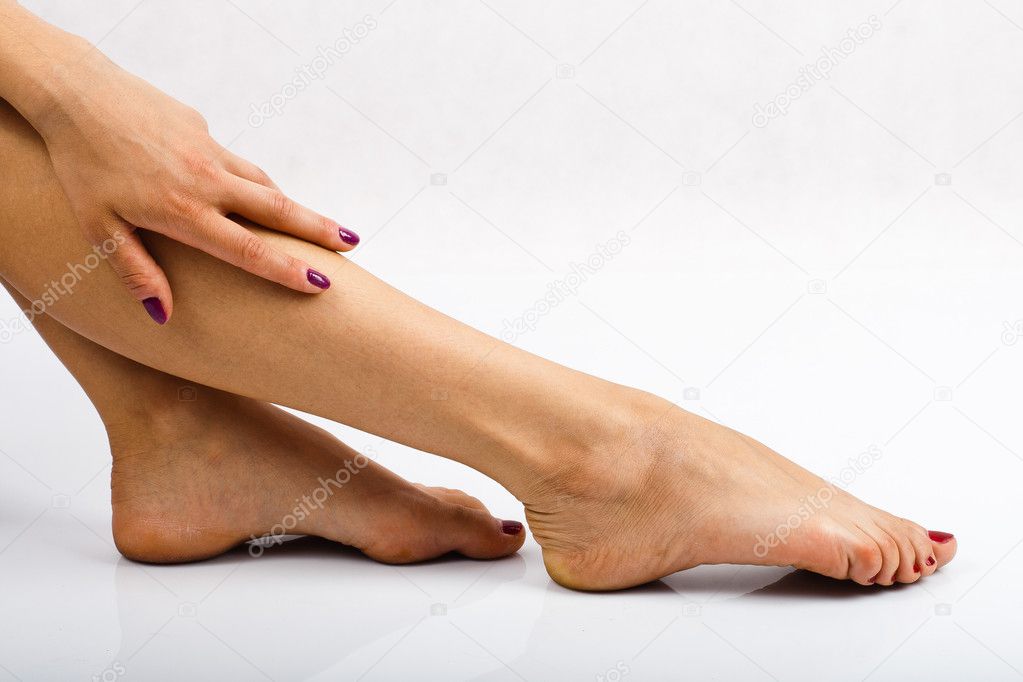 Close up of a tired female legs with hand.