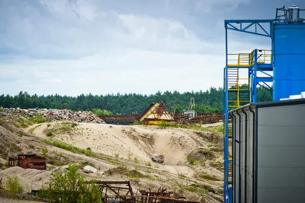 Непригодное оборудование и новое здание на гравийной шахте — стоковое фото