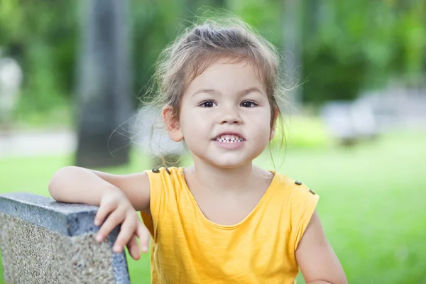Das kleine Mädchen sitzt im Urlaub auf einer Bank — Stockfoto
