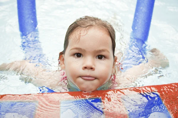 Маленькая девочка плавает в бассейне в отпуске — стоковое фото