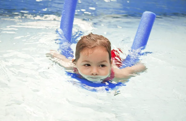 Маленькая девочка плавает в бассейне в отпуске — стоковое фото