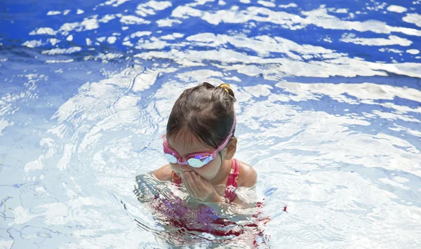 The little girl swims in the pool on vacation — Stock Photo, Image
