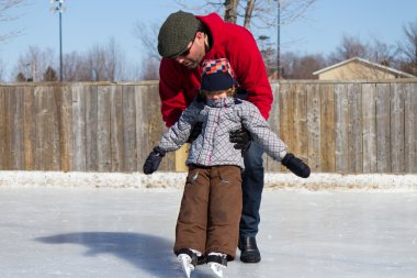 Father teaching son how to ice skate