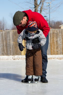 Father teaching son how to ice skate