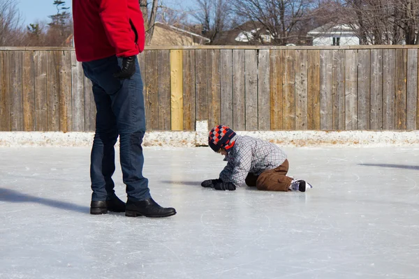 Pai ensinando filho como patinar no gelo — Fotografia de Stock