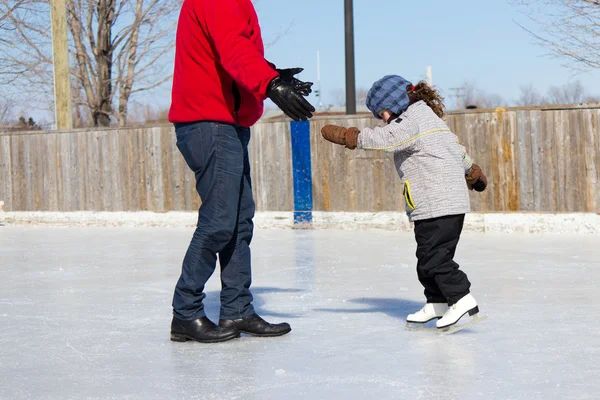 Padre enseñando a su hija a patinar sobre hielo — Foto de Stock