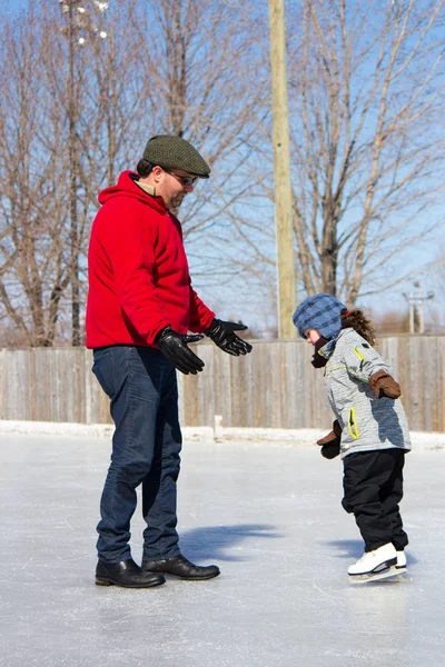 Father teaching daughter how to ice skate — Stock Photo, Image