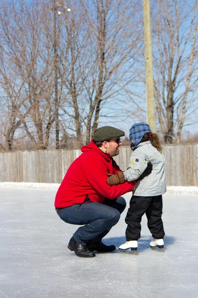 Отец учит дочь кататься на коньках — стоковое фото