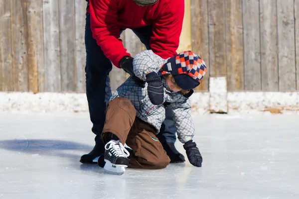 Батько навчає сина кататися на ковзанах — стокове фото