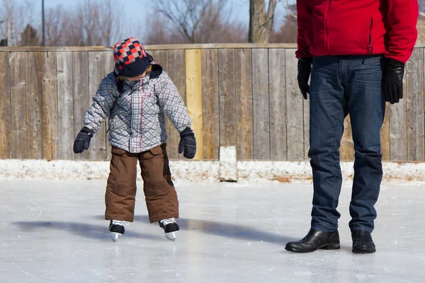 Père enseignant à son fils comment patiner sur glace — Photo