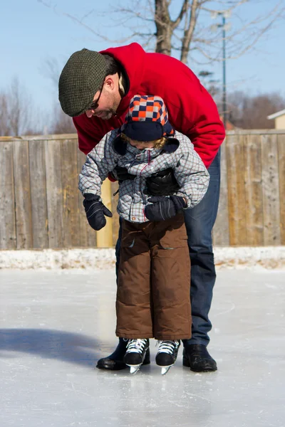 Padre enseñando a hijo a patinar sobre hielo — Foto de Stock