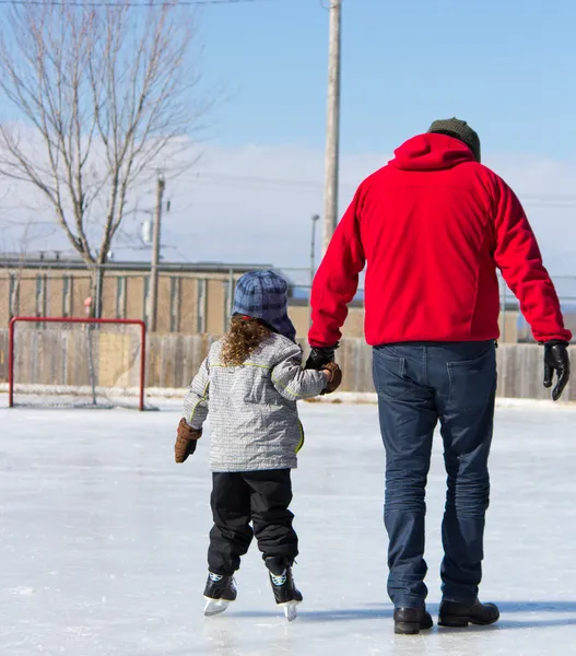 Père enseignant à sa fille comment patiner sur glace — Photo